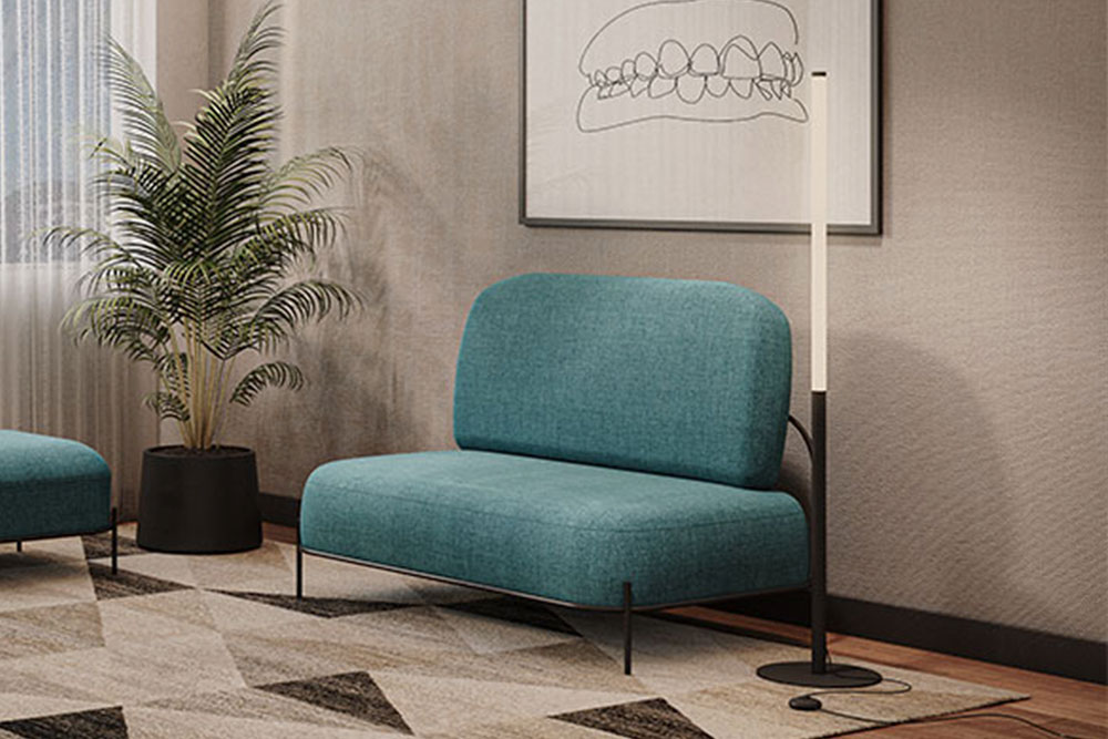 Fotografía de uno de los sillones de sala de espera color azul claro colocado frente a una pared color blanco.