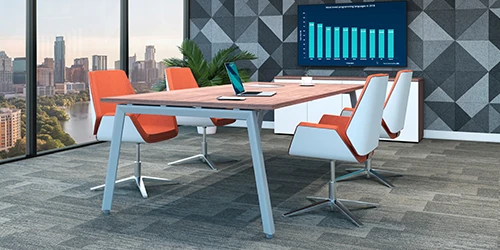 Mobiliario de oficina: fotografía de mesa rectangular color beige y alrededor sillas color blanco con naranja.