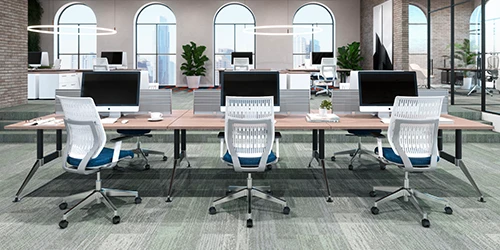 Mobiliario de oficina: fotografía de mesa rectangular larga con computadoras y enfrente sillas color blanco con cojín azul.