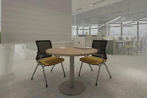 Mobiliario de oficina: fotografía de mesa mediana redonda color beige con dos sillas color negro y cojín amarillo.