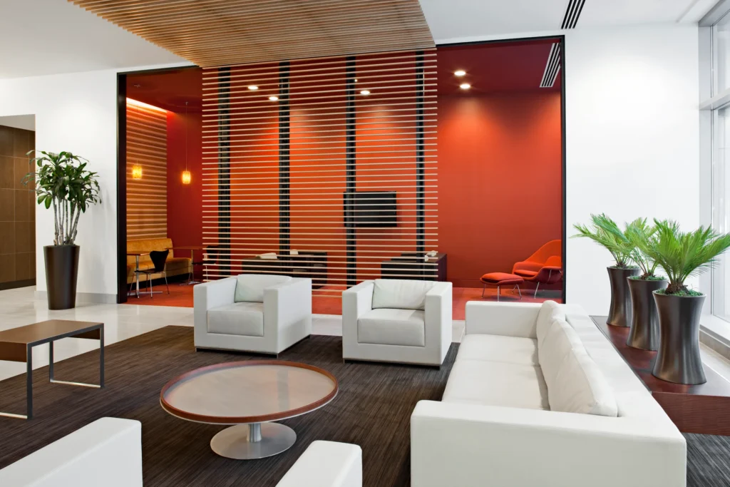 Interiorismo corporativo: Fotografía de una sala de espera color blanco y en el centro una mesa circular.