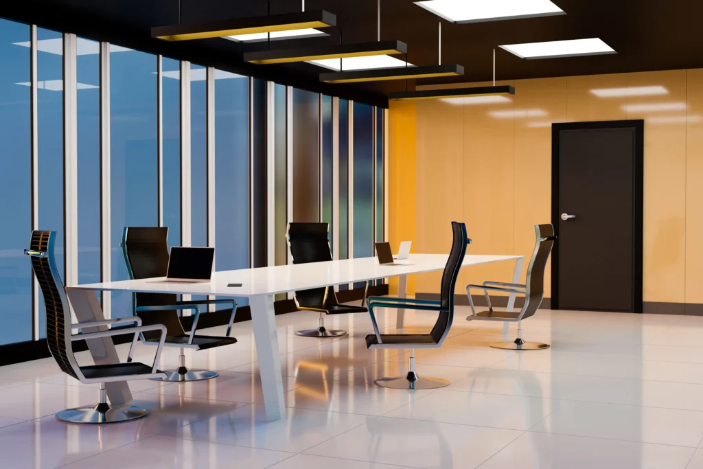 Interiorismo corporativo: Fotografía de una mesa rectangular blanca con sillas color negro alrededor.